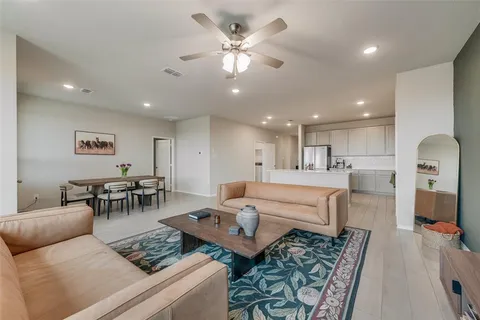 a living room with furniture and a view of kitchen