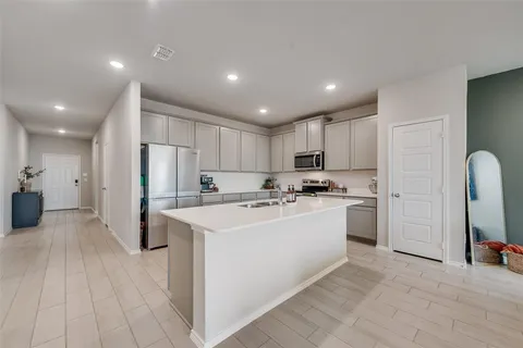 a kitchen with refrigerator and a sink
