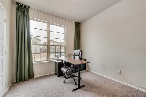 a view of a workspace with furniture and a window