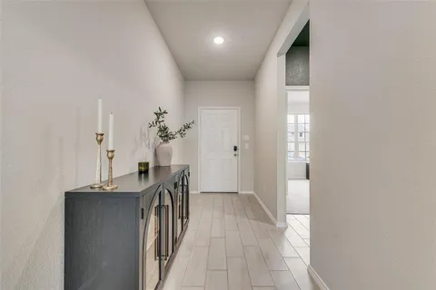 a view of a hallway to a livingroom with furniture