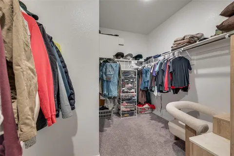 a view of walk in closet with clothes and shoes