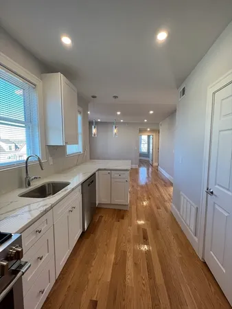 a large kitchen with stainless steel appliances granite countertop a large counter top a sink and a stove