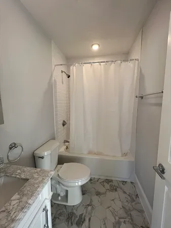 a bathroom with a granite countertop sink toilet and shower