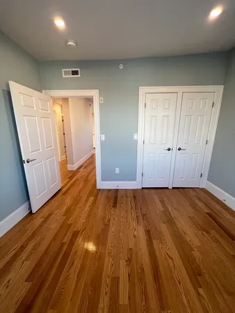 an empty room with wooden floor and entrance