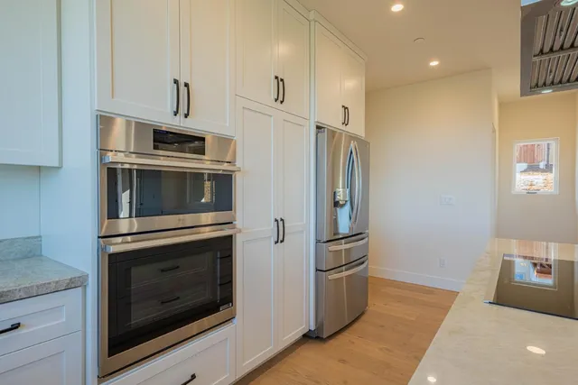 a kitchen with white cabinets and white appliances