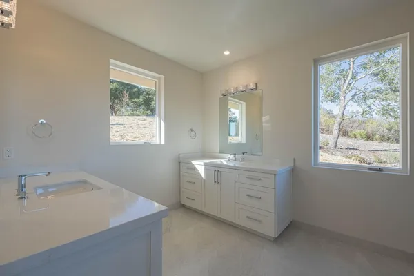 a bathroom with a double vanity sink a and a window