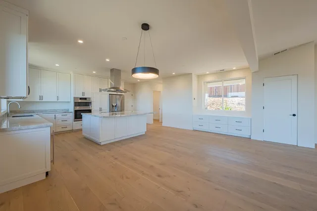an empty room with a fireplace and cabinet