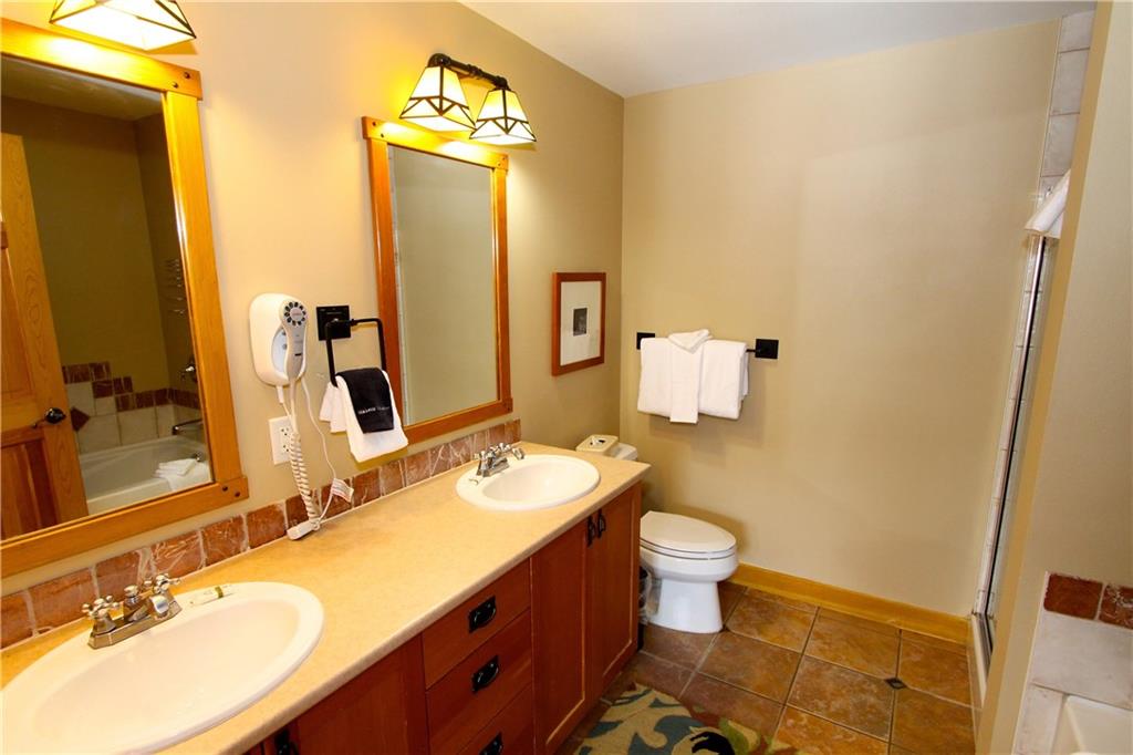 910 Copper Road, Unit 303 Copper Mountain, CO 80443 - Photo 15 of 26 a bathroom with a granite countertop sink toilet and mirror