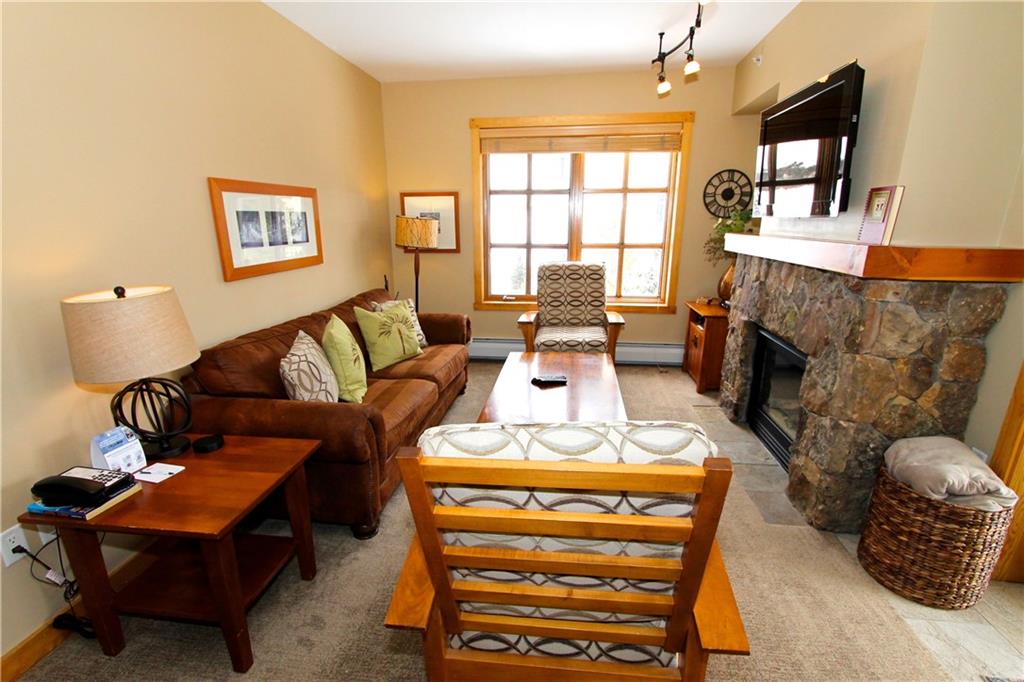 910 Copper Road, Unit 303 Copper Mountain, CO 80443 - Photo 7 of 26 a living room with furniture a fireplace and a flat screen tv