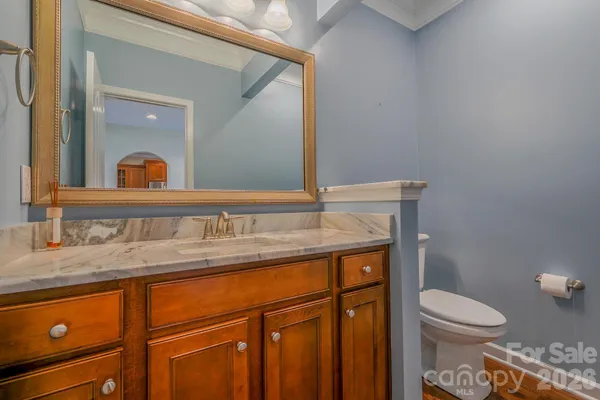 a bathroom with a granite countertop toilet sink and mirror