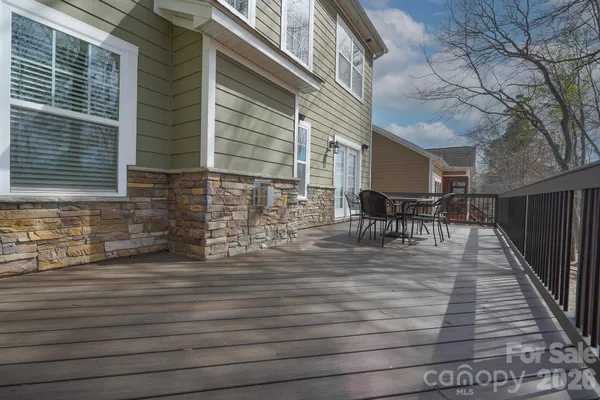 a view of a patio with table and chairs with wooden floor and fence