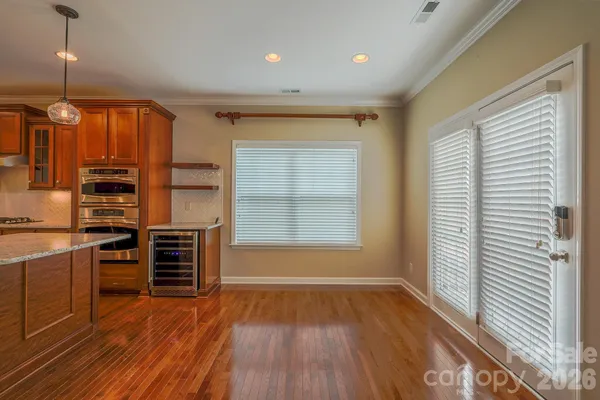 a view of a kitchen with wooden floor and electronic appliances