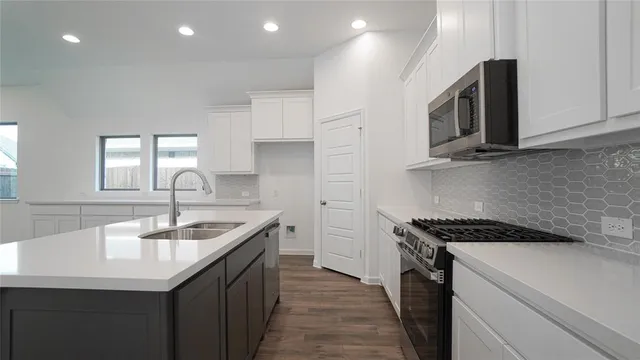 a kitchen with a stove a sink and a microwave