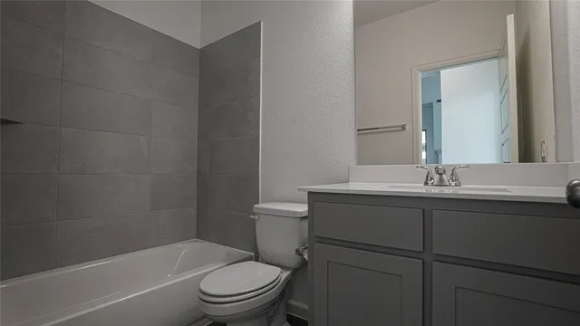 a bathroom with a toilet sink vanity and mirror