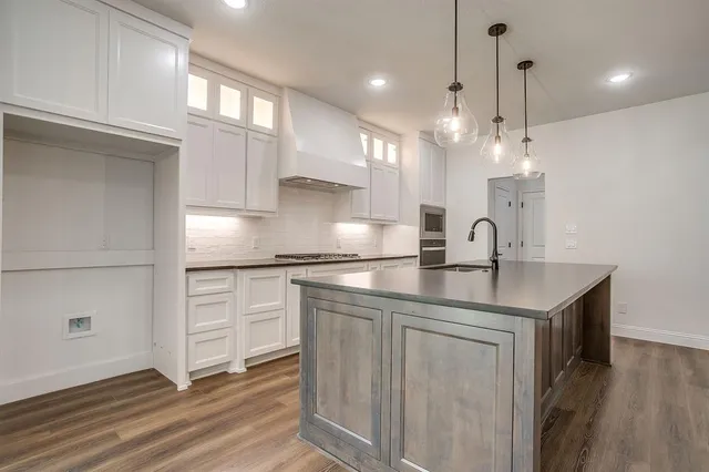 a kitchen with kitchen island a sink stainless steel appliances and cabinets
