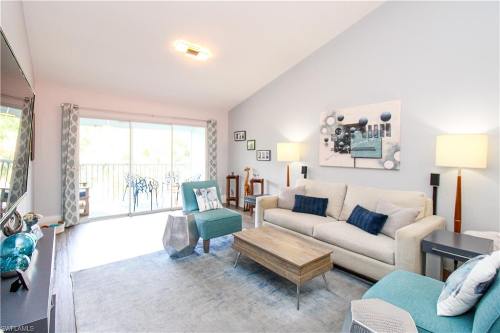 225 Robin Hood Circle, Unit 203 Naples, FL 34104 - Photo 21 of 50 Living room with high vaulted ceiling and hardwood / wood-style floors