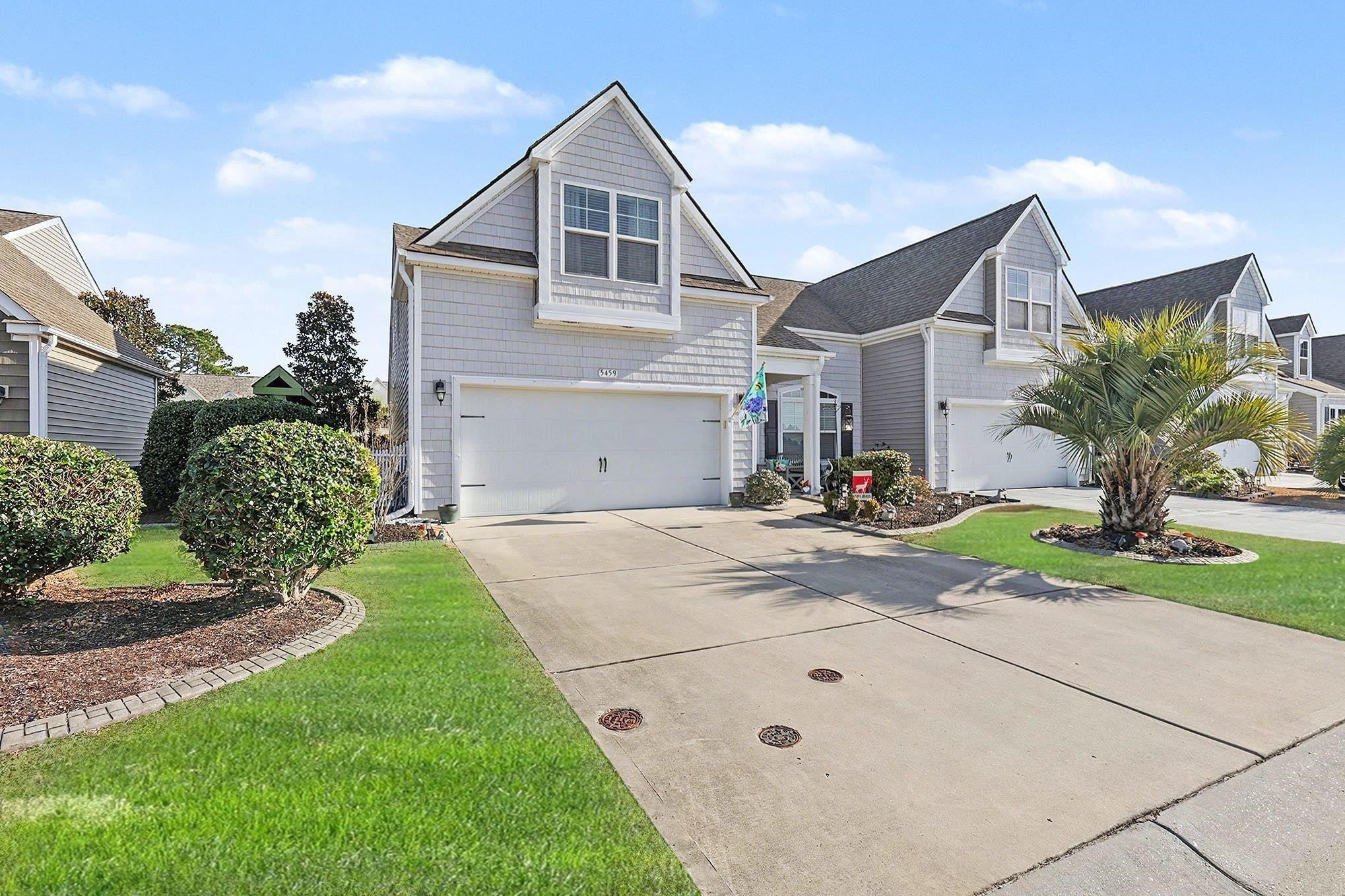 View of front of property with driveway and an attached garage