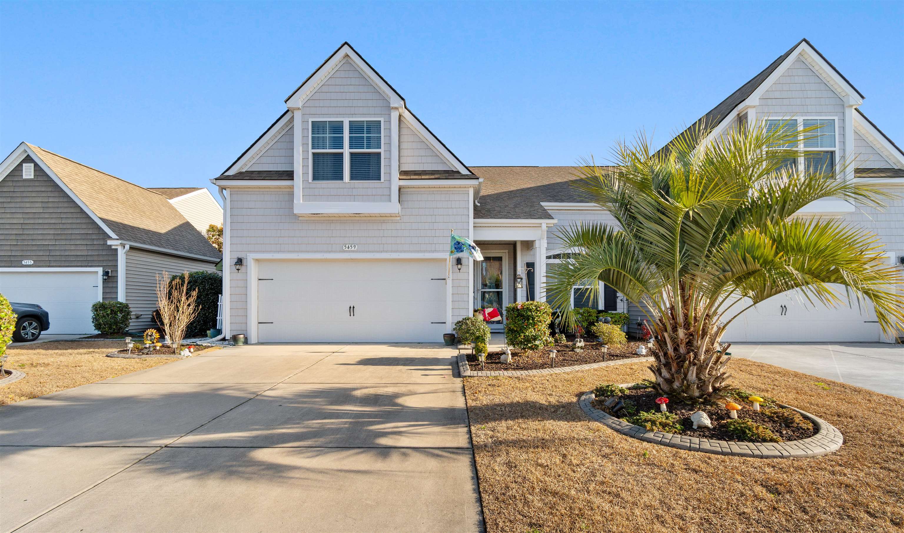 View of front of property with driveway and an attached garage