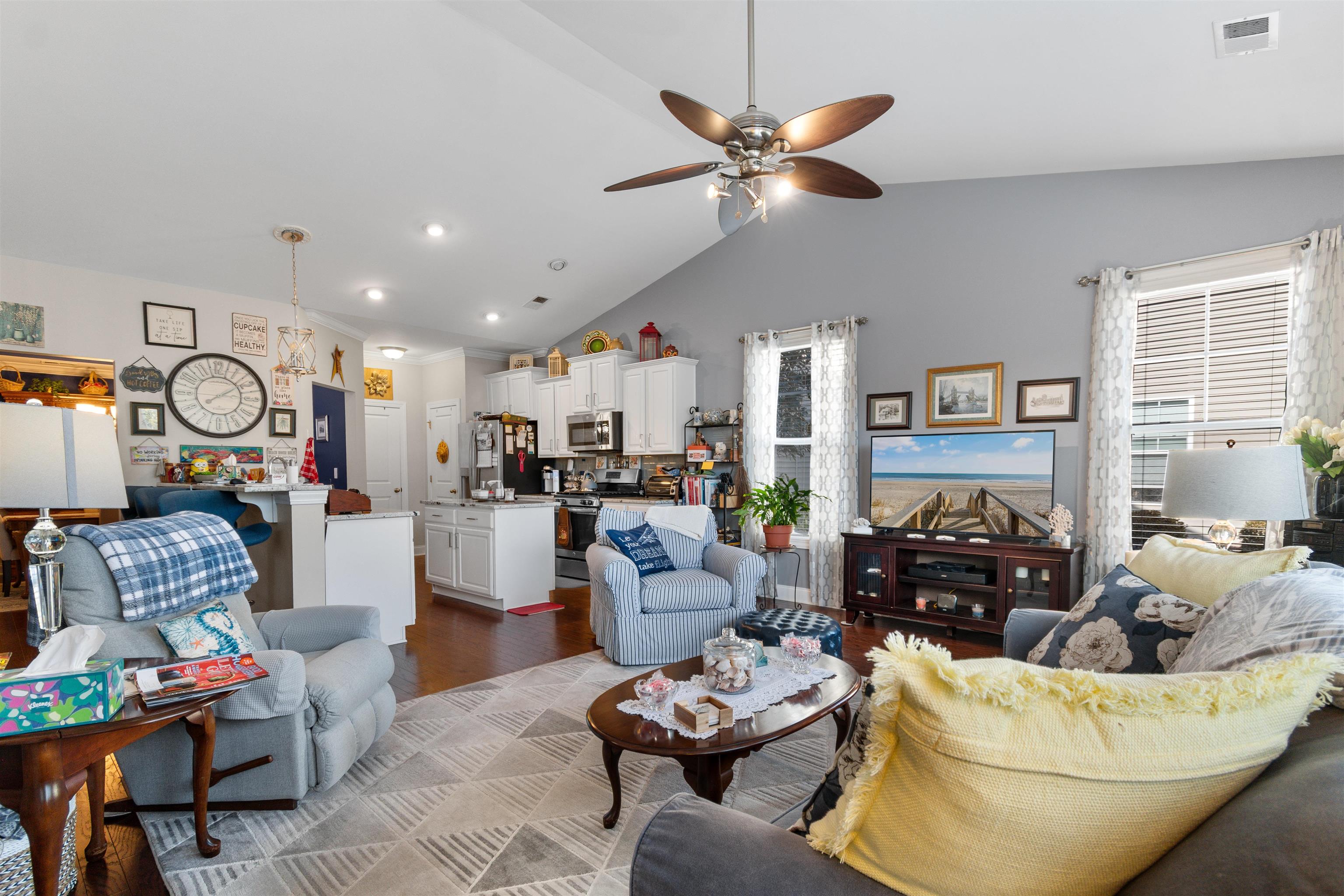 5459 Elba Way, Unit 1501 Myrtle Beach, SC 29579 - Photo 10 of 31 Living area featuring lofted ceiling, wood finished floors, healthy amount of natural light, and a ceiling fan