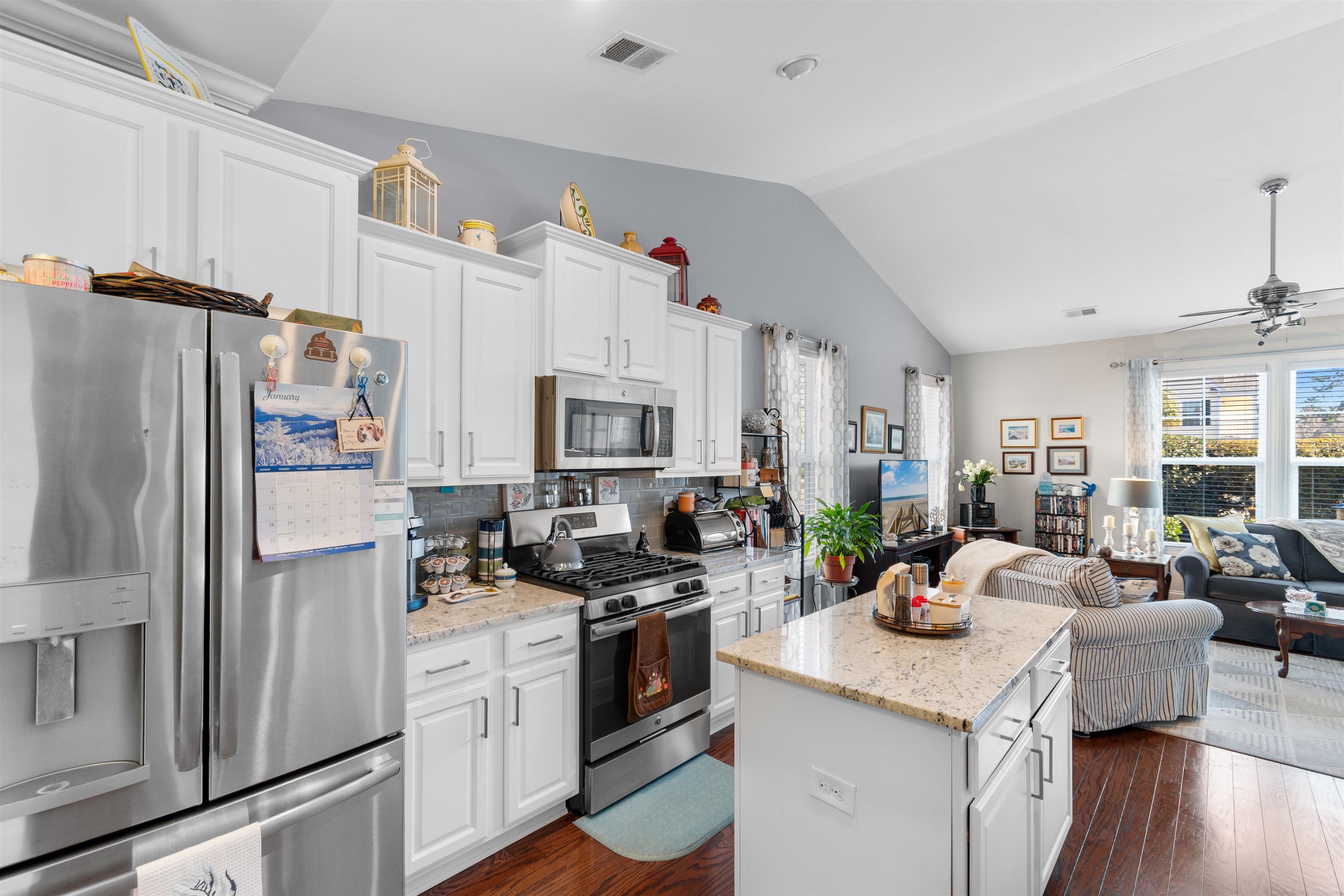 5459 Elba Way, Unit 1501 Myrtle Beach, SC 29579 - Photo 31 of 31 Kitchen with stainless steel appliances, open floor plan, white cabinets, lofted ceiling, and light stone counters