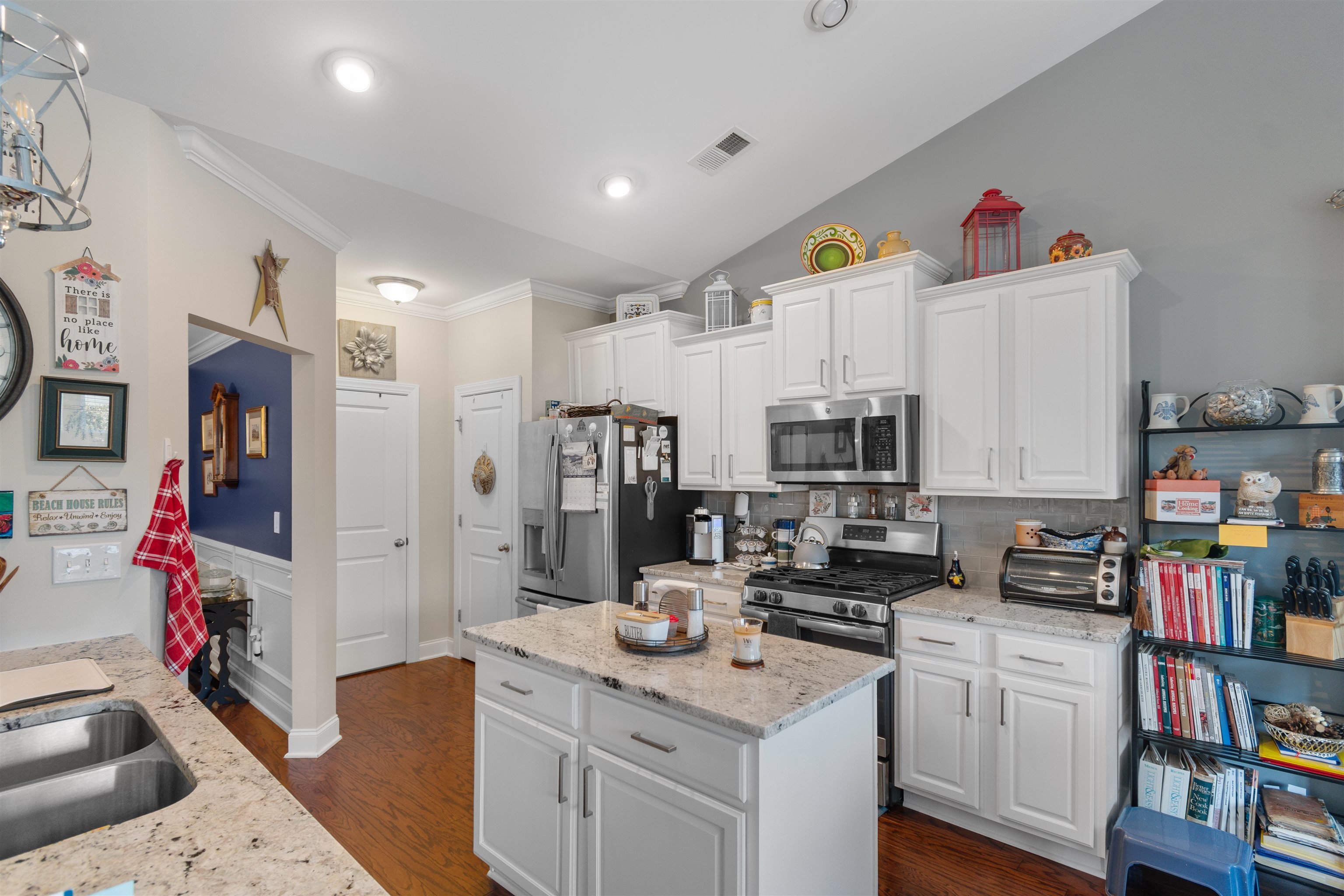 5459 Elba Way, Unit 1501 Myrtle Beach, SC 29579 - Photo 7 of 31 Kitchen with white cabinetry, light stone countertops, ornamental molding, dark wood-style flooring, and stainless steel appliances