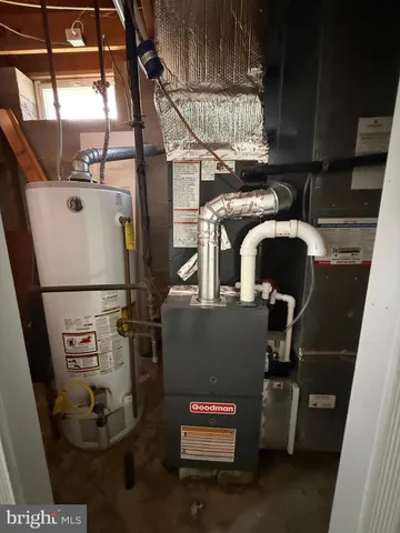 a room with water heater and racks on the wall