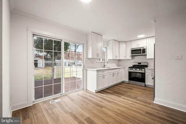 a kitchen with granite countertop a stove a sink and a microwave