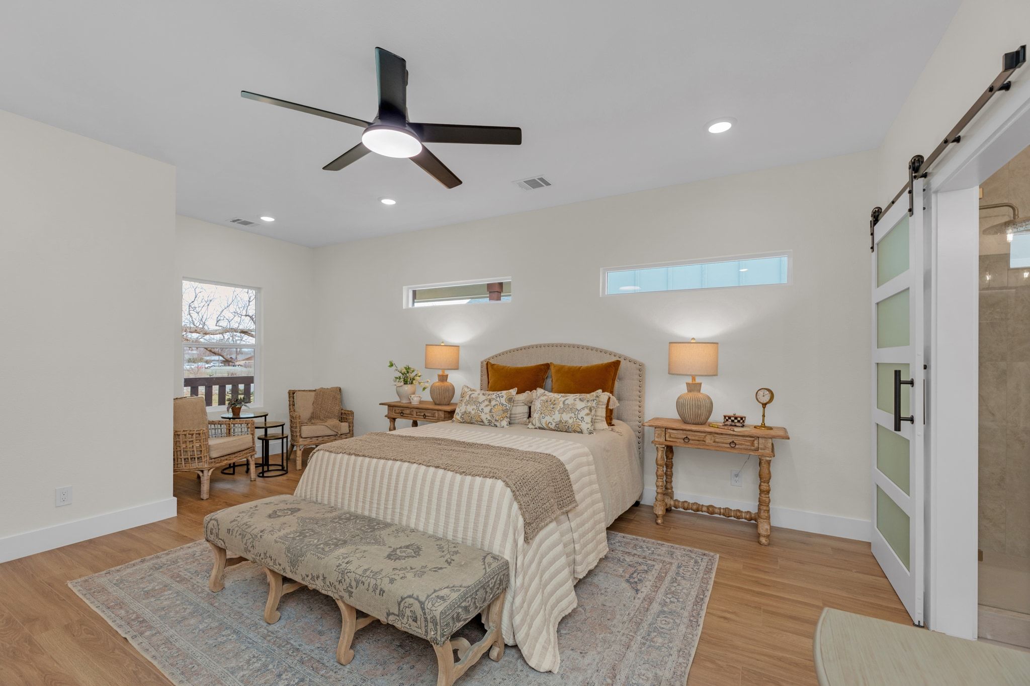 2102 South Church Street Georgetown, TX 78626 - Photo 11 of 40 Bedroom featuring a barn door, Optimax Performance Azalea Oak Hybrid Resilient Flooring that is a wood based. Ceiling fan and recessed lighting.