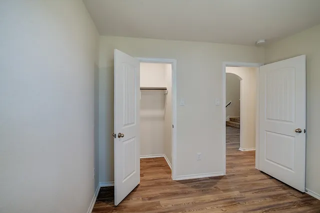 an empty room with wooden floor and closet