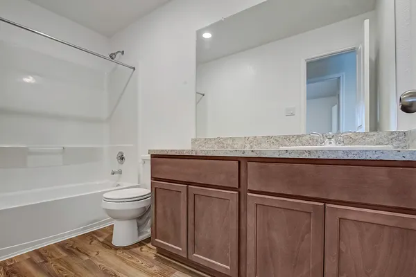 a bathroom with a granite countertop sink toilet and shower
