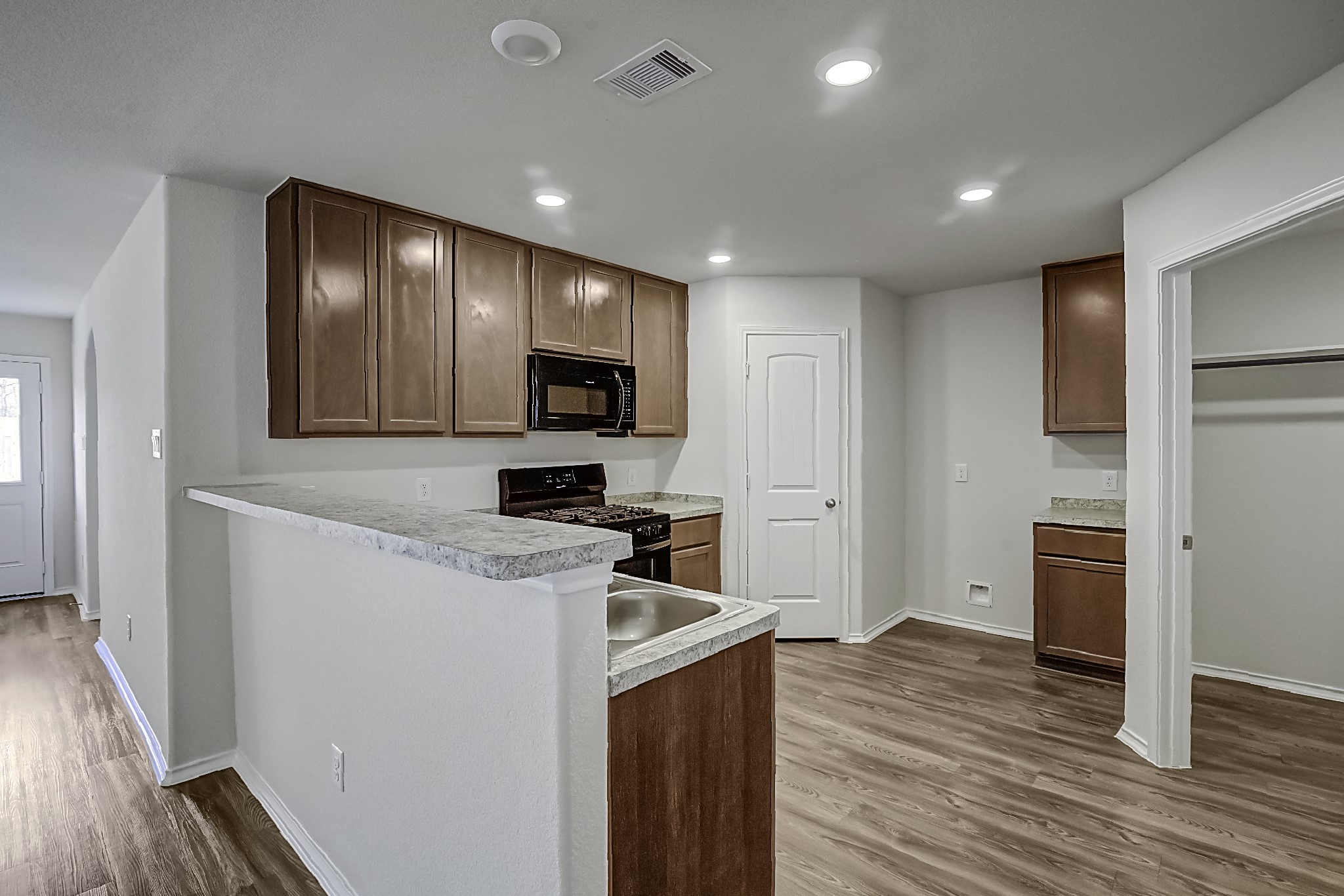 14468 Conifer Drive Conroe, TX 77302 - Photo 5 of 21 a kitchen with a refrigerator stove and wooden floor