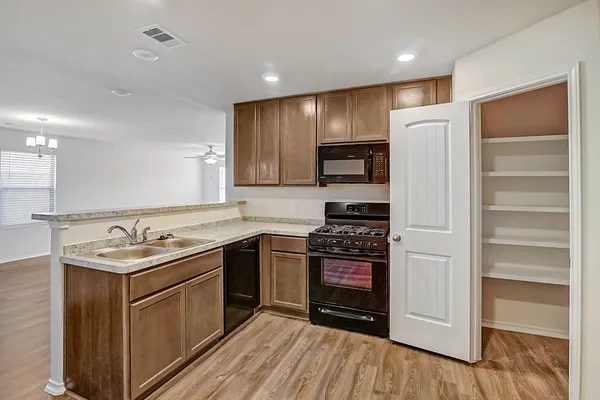 a kitchen with stainless steel appliances granite countertop a stove a refrigerator and a sink