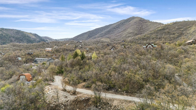 1572 Lower Canyon, Unit 72 Midway, UT 84049 - Photo 1 of 4 Elevated mountain setting featuring a winding dirt road and extensive tree coverage