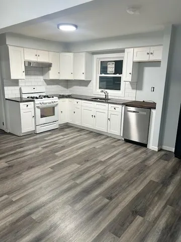 a kitchen with stainless steel appliances granite countertop a stove a sink and a microwave