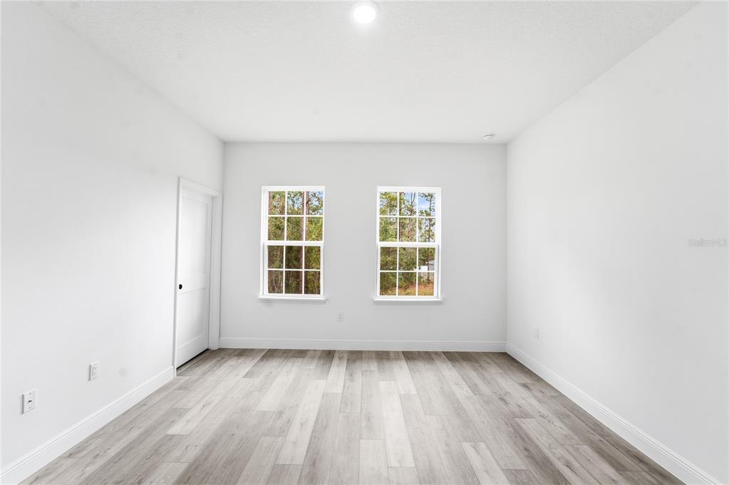 6312 Southwest 144th Lane Road Ocala, FL 34473 - Photo 23 of 32 an empty room with wooden floor and windows