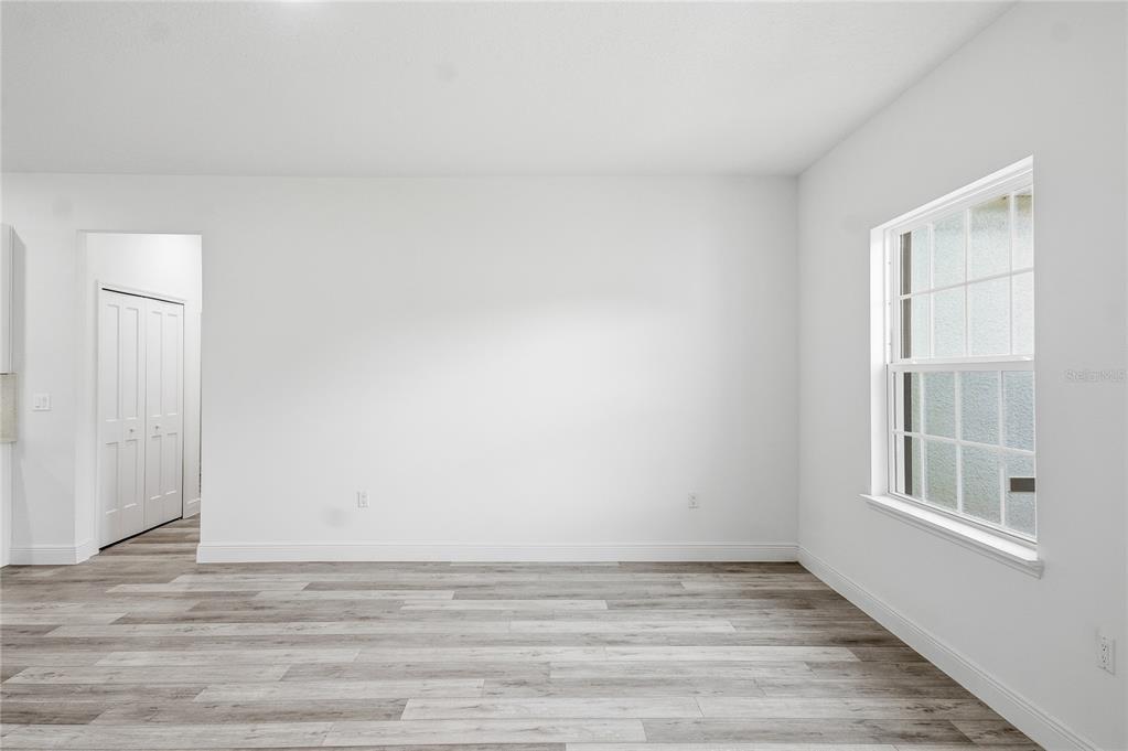 6312 Southwest 144th Lane Road Ocala, FL 34473 - Photo 7 of 32 a view of an empty room with wooden floor and a window