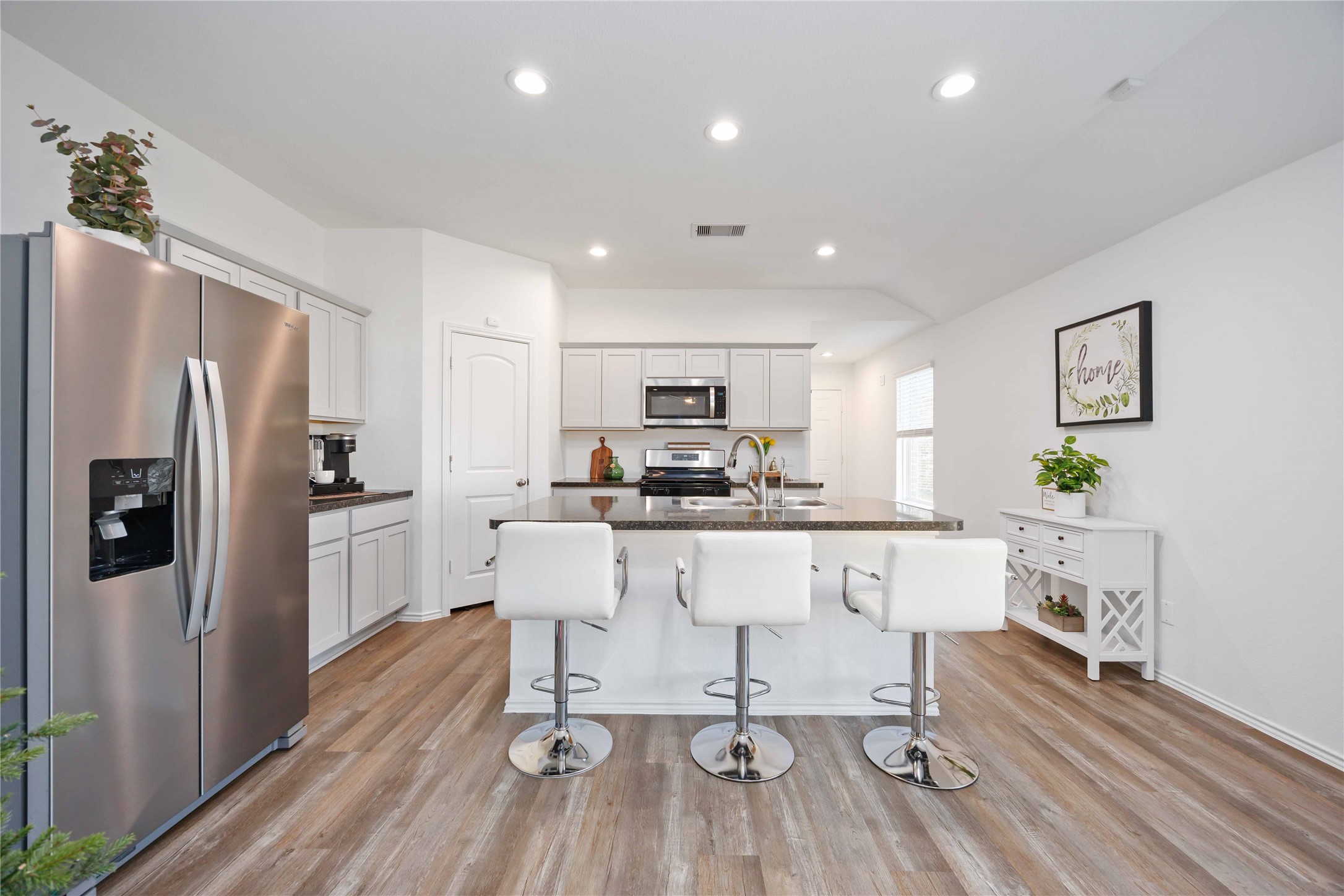 24034 Sunview Vly Drive Spring, TX 77373 - Photo 14 of 43 a kitchen with stainless steel appliances granite countertop a refrigerator a stove top oven a sink dishwasher and white cabinets with wooden floor