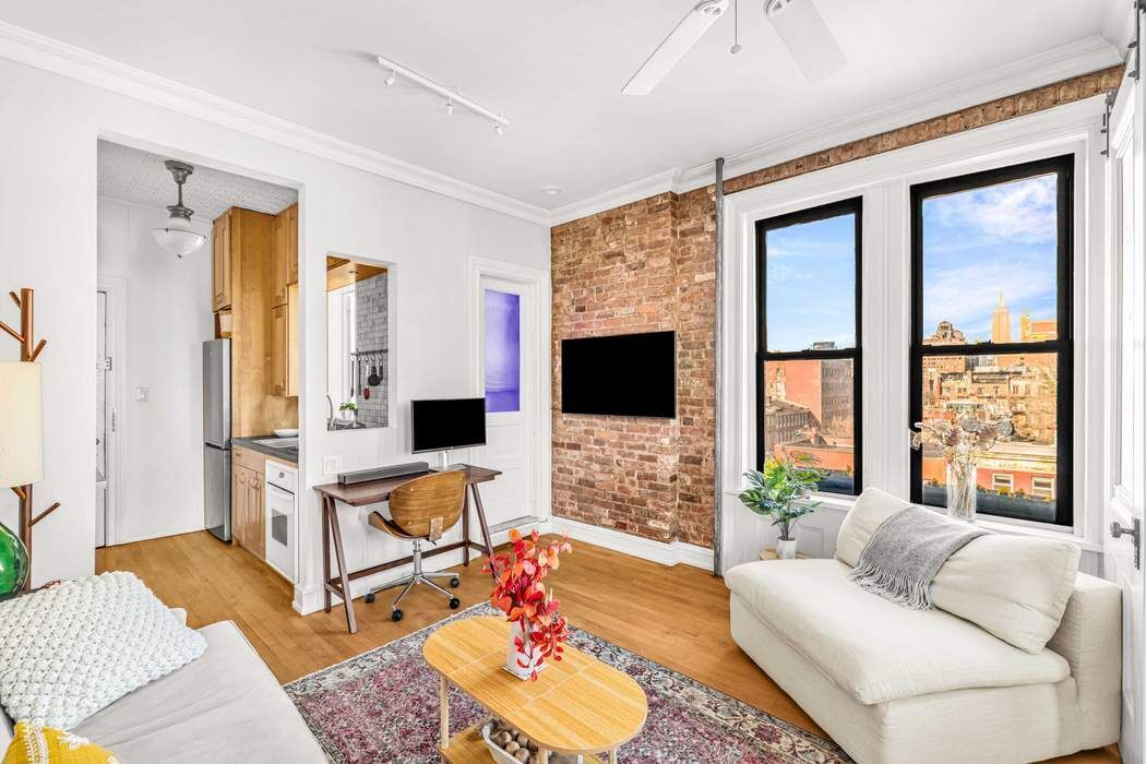 64 MacDougal Street, Unit 22 Manhattan, NY 10012 - Photo 3 of 13 a living room with furniture and a flat screen tv