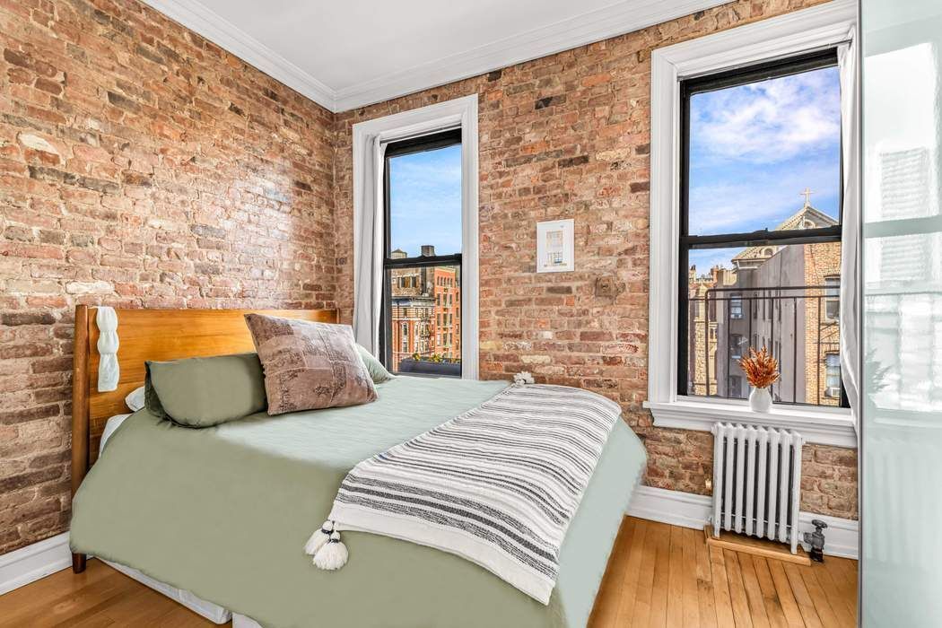 64 MacDougal Street, Unit 22 Manhattan, NY 10012 - Photo 4 of 13 a bedroom with a bed and wooden floor