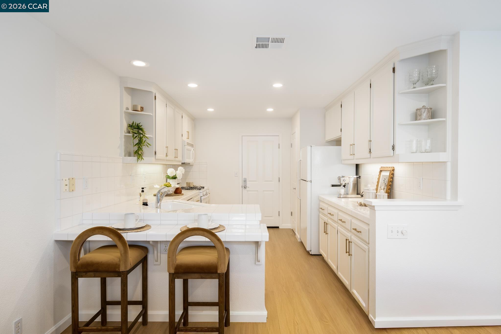 7110 Briza Loop San Ramon, CA 94582 - Photo 8 of 25 a kitchen with granite countertop white cabinets and chairs