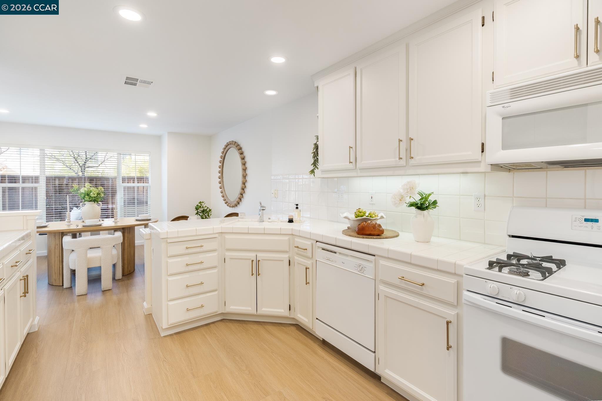 7110 Briza Loop San Ramon, CA 94582 - Photo 10 of 25 a kitchen with white cabinets and white appliances