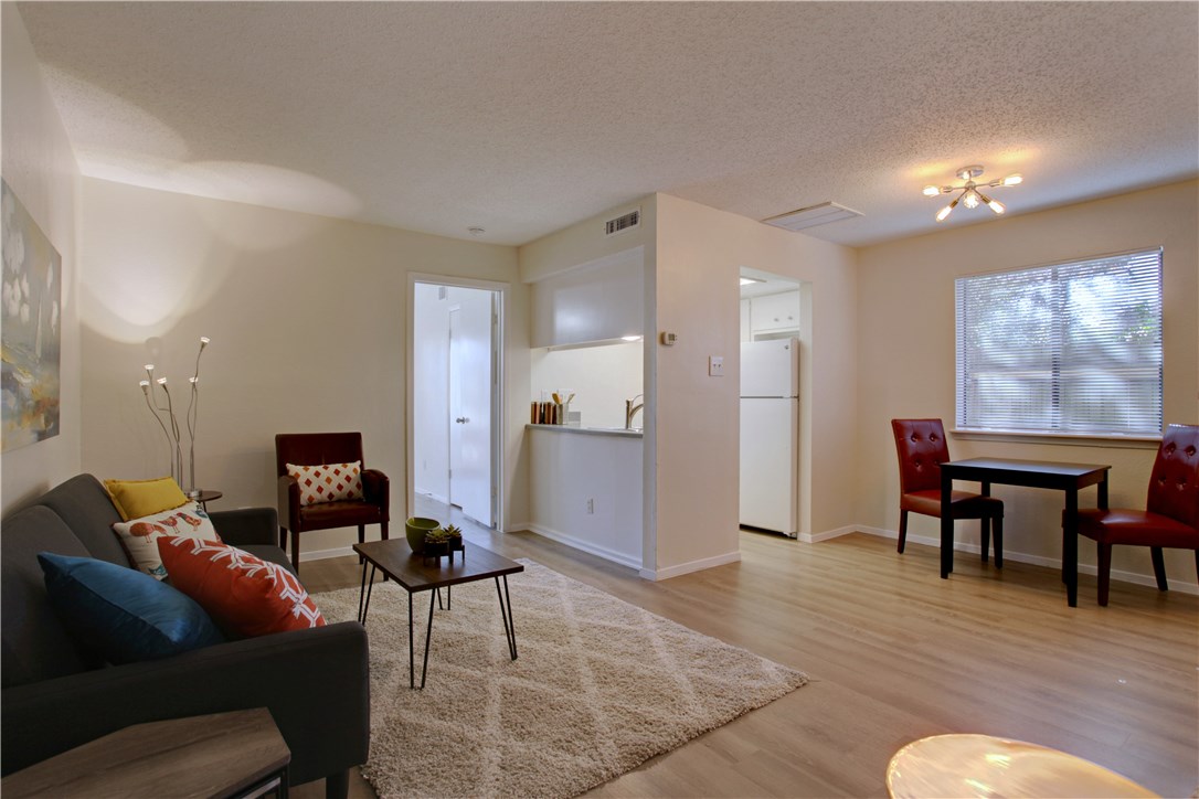 9079 Jollyville Road, Unit 303 Austin, TX 78759 - Photo 3 of 25 a living room with furniture and a dining table with kitchen appliances