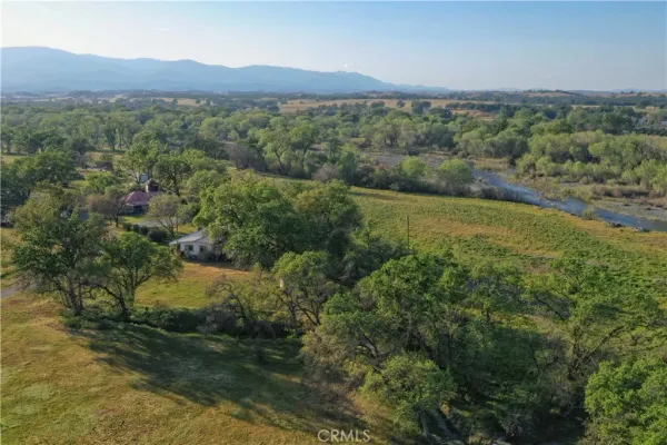 an aerial view of green landscape with trees houses and mountain view