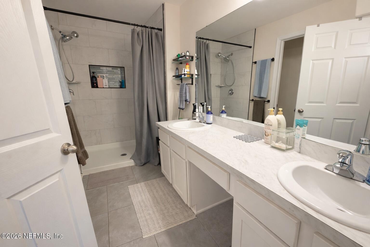 597 Coastline Way Street St. Augustine, FL 32092 - Photo 14 of 21 a bathroom with a sink a mirror a vanity and a shower