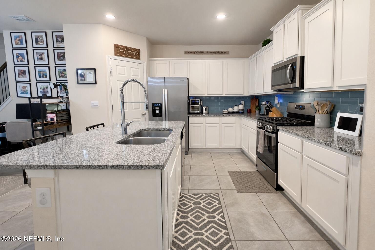 597 Coastline Way Street St. Augustine, FL 32092 - Photo 6 of 21 a kitchen with stainless steel appliances granite countertop a sink and cabinets
