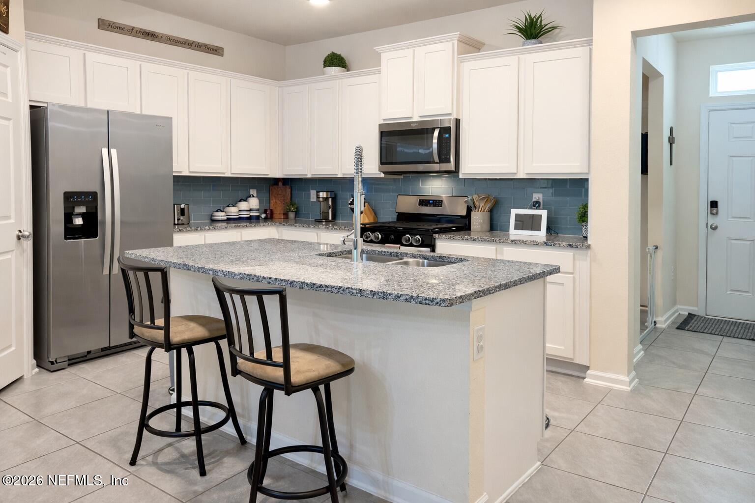 597 Coastline Way Street St. Augustine, FL 32092 - Photo 7 of 21 a kitchen with stainless steel appliances granite countertop a stove a sink a microwave a refrigerator and cabinets