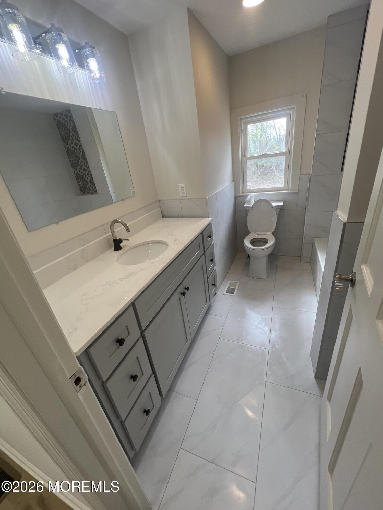 33 Weaverville Road Freehold, NJ 07728 - Photo 3 of 12 a bathroom with a sink a toilet and a mirror