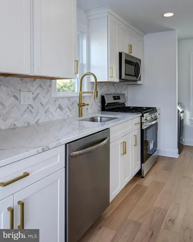 a kitchen with stainless steel appliances granite countertop a sink a stove a microwave and cabinets