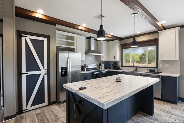 a kitchen with a refrigerator a sink and wooden floor