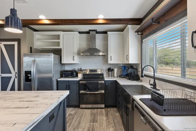 a kitchen with kitchen island granite countertop a sink stainless steel appliances and cabinets